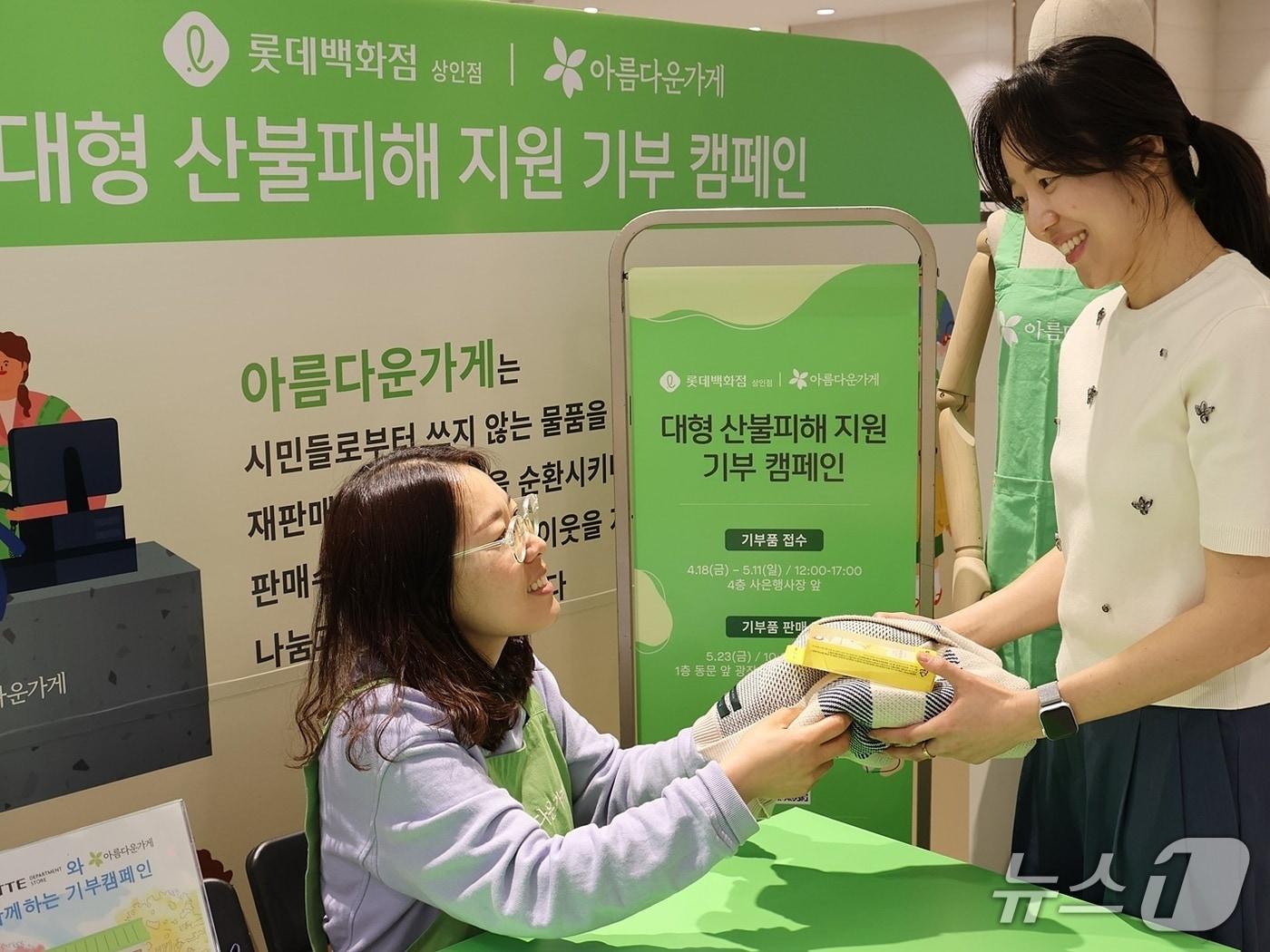 본문 이미지 - 롯데백화점 상인점 4층 사은행사장에 마련된 아름다운가게 접수처를 통해 고객이 의류를 기부하고 있다.(롯데백화점 제공. 재판매 및 DB 금지)