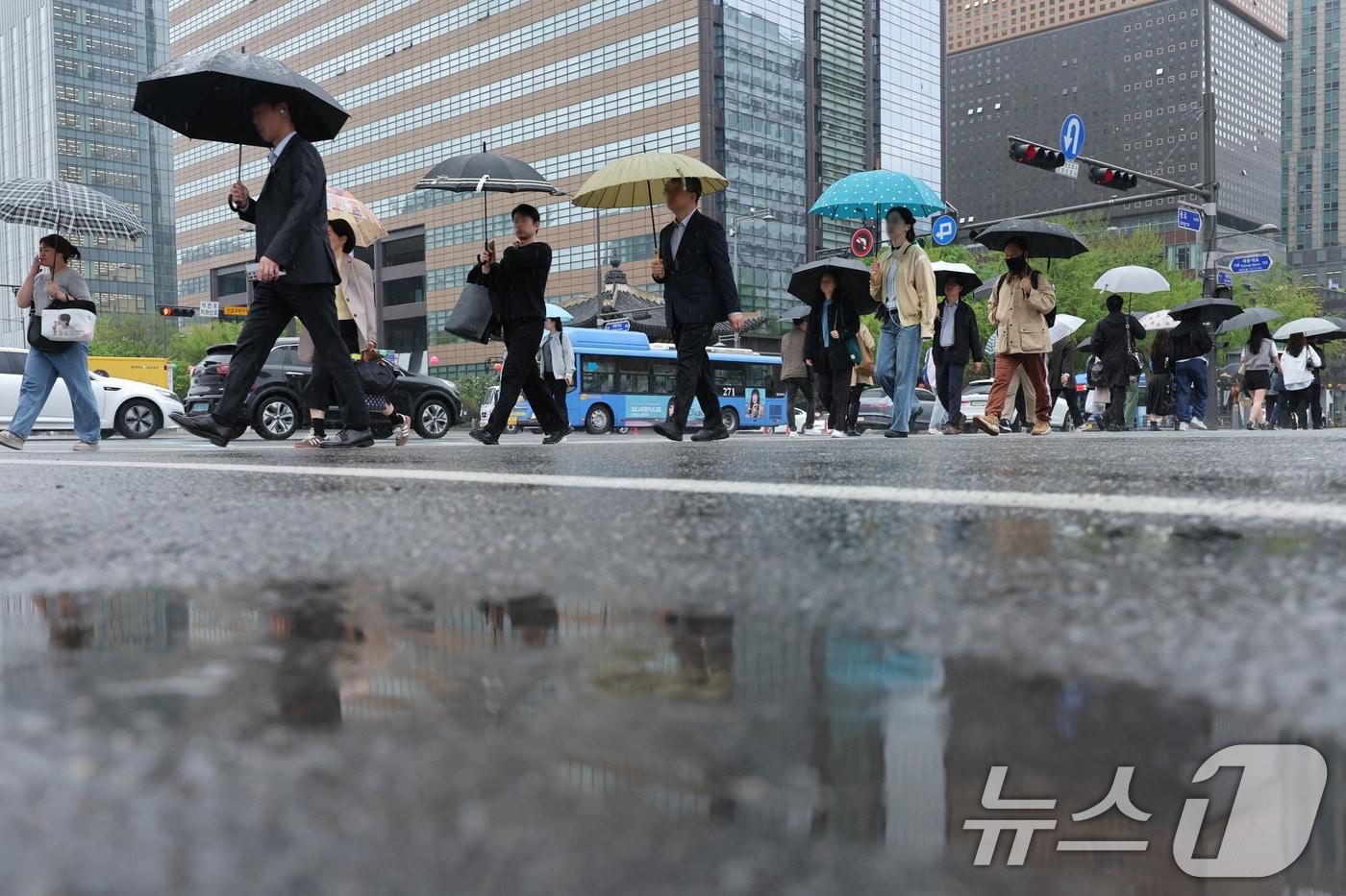 봄비가 내린 22일 서울 광화문네거리에서 우산을 쓴 시민들이 출근하고 있다. 기상청은 이날 전국에서 봄비가 내리며 영남은 최대 80㎜, 수도권은 최대 50㎜에 달하는 많은 비가 내릴 것으로 예보했다. 2025.4.22/뉴스1 ⓒ News1 신웅수 기자