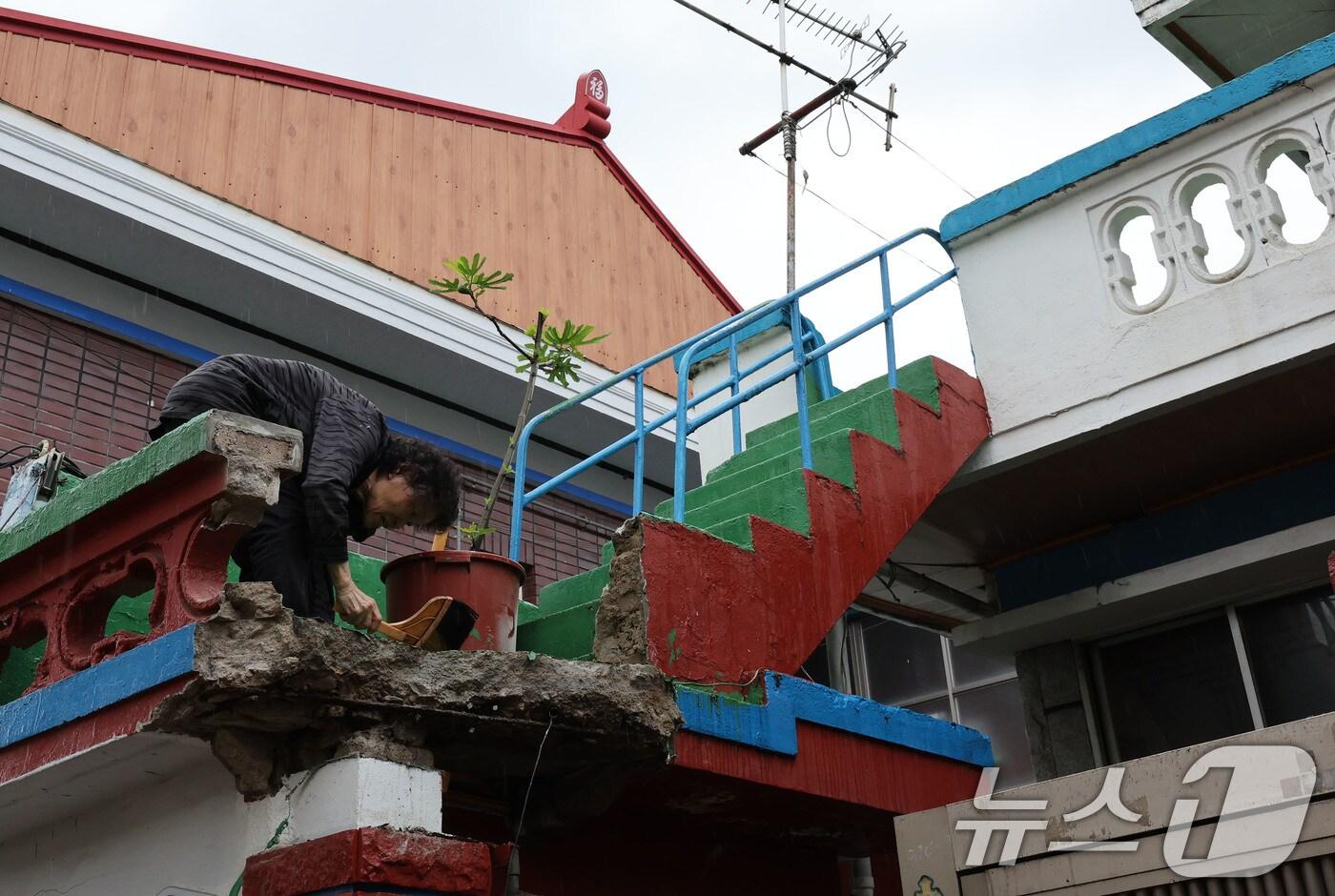지난 21일 오후 10시 20분쯤 광주 북구 중흥동 소재 주택의 담장과 외벽에 균열이 발생해 무너졌다. 사진은 집주인이 빗자루질 하고 있는 모습. ⓒ News1 박지현 기자