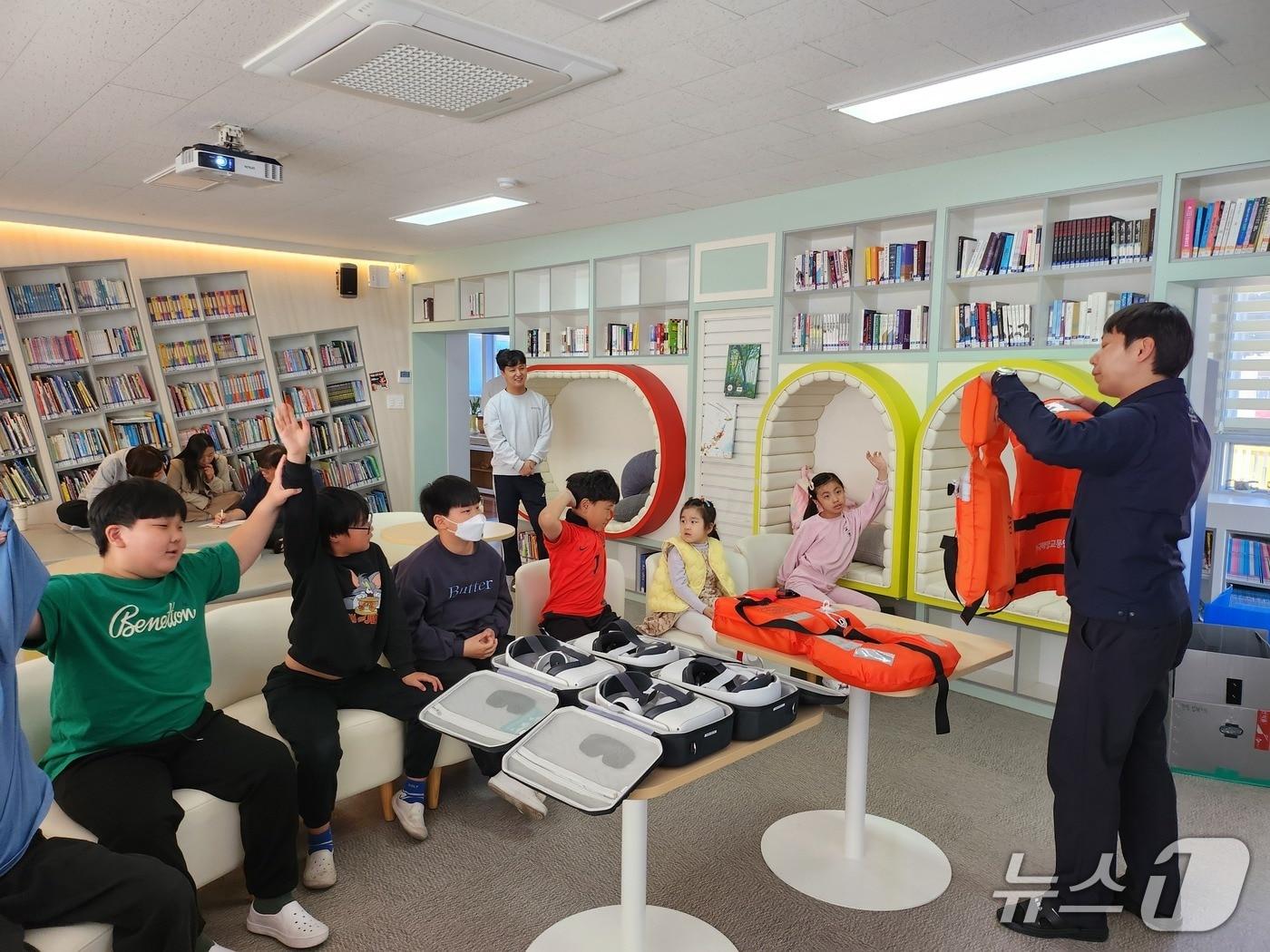 본문 이미지 - 한국해양교통안전공단(KOMSA) 통영운항관리센터 관계자가 학생들에게 구명조끼 착용법을 가르치고 있다.(통영운항관리센터 제공. 재판매 및 DB금지.)