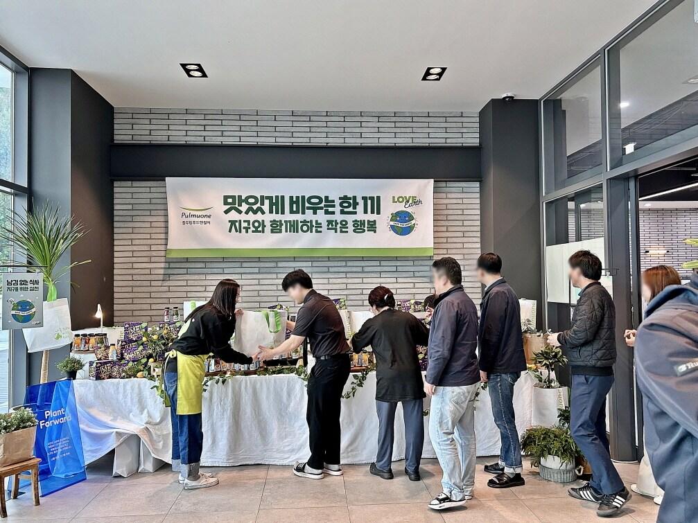 본문 이미지 - 풀무원푸드앤컬처 임직원이 위탁급식 사업장에서 식사를 깔끔하게 마친 고객들에게 풀무원 &#39;아임리얼&#39;, &#39;고단백넛츠바사삭&#39;, &#39;리유저블 장바구니&#39; 등을 선물로 제공하고 있다.&#40;풀무원푸드앤컬처 제공&#41; 