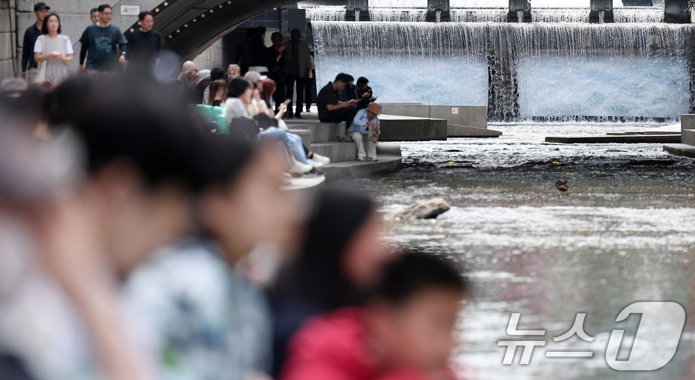 낮 최고기온이 25도를 기록하는 등 초여름 날씨를 보인 23일 오후 서울 중구 청계천을 찾은 시민들이 독서를 하고 있다. 2025.4.23/뉴스1 ⓒ News1 김성진 기자