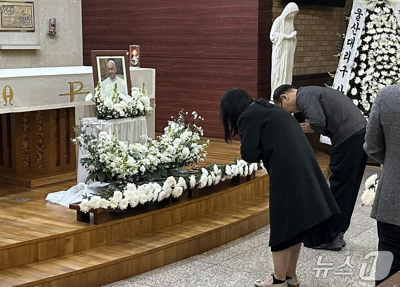 본문 이미지 - 23일 울산시 중구 복산성당 소성전에 마련된 프란치스코 교황 분향소에서 천주교 신자들이 헌화를 하고 있다. 2025.4.23/뉴스1 ⓒ News1 조민주 기자