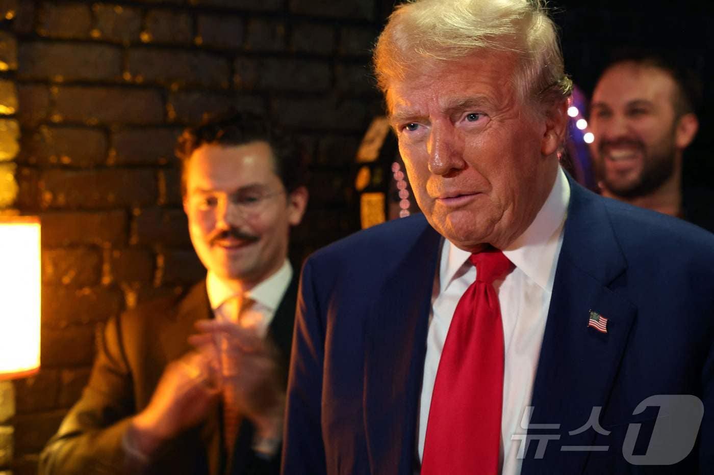 도널드 트럼프 미국 대통령이 대선후보이던 지난해 9월 미국 뉴욕의 한 펍에서 비트코인으로 치즈버거를 구매하고 있다. (자료사진) ⓒ AFP=뉴스1