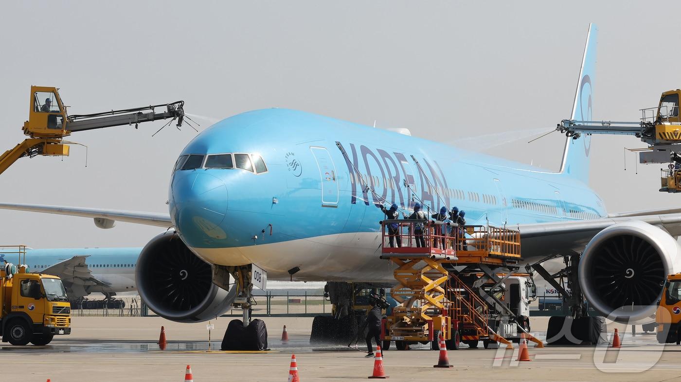 본문 이미지 - 24일 오전 인천 중구 인천국제공항 대한항공 격납고에서 직원들이 봄을 맞아 항공기 동체를 세척하고 있다. 이날 세척한 항공기는 보잉 777-300ER 기종으로 대한항공의 새 도장이 적용된 기체다. ⓒ 뉴스1 장수영 기자