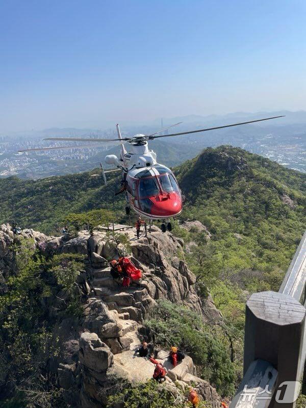 본문 이미지 -  소방 당국이 경기 과천시 중앙동 관악산 정상 부근에서 60대 남성을 구조하고 있다.(경기도소방재난본부 제공, 재판매 및 DB 금지)/뉴스1 