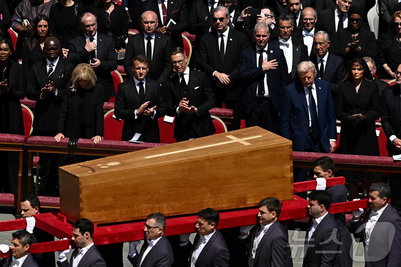 도널드 트럼프 미국 대통령과 부인 멜라니아 여사가 26일 &#40;현지시간&#41; 바티칸의 성 베드로 광장에서 열린 프란치스코 교황의 장례 미사 중 관이 옮겨 지는 모습을 지켜 보고 있다. 2025.04,27 ⓒ 로이터=뉴스1 