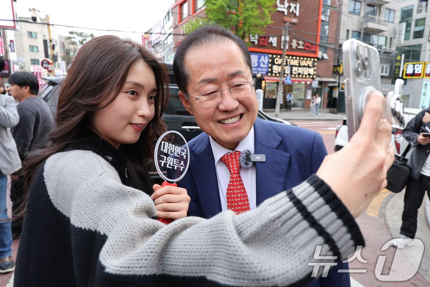 홍준표 국민의힘 대선 경선 후보가 27일 오후 서울 마포구 홍대 레드로드에서 열린 현장 기자간담회에 참석하며 시민들과 기념 촬영을 하고 있다. 2025.4.27/뉴스1 ⓒ News1 신웅수 기자