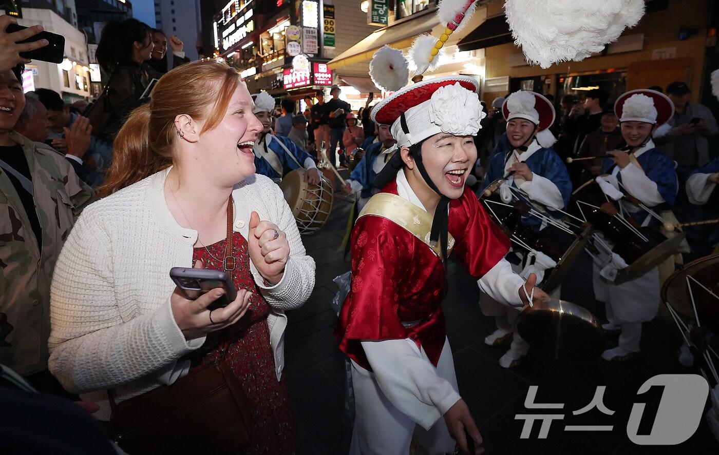 불기 2569년(2025년) 부처님오신날(5월 5일)을 앞둔 27일 오후 한 외국인 관광객이 서울 종로구 인사동 일대에서 열린 연등놀이에서 풍물놀이패의 공연을 관람하고 있다. 2025.4.27/뉴스1 ⓒ News1 김진환 기자