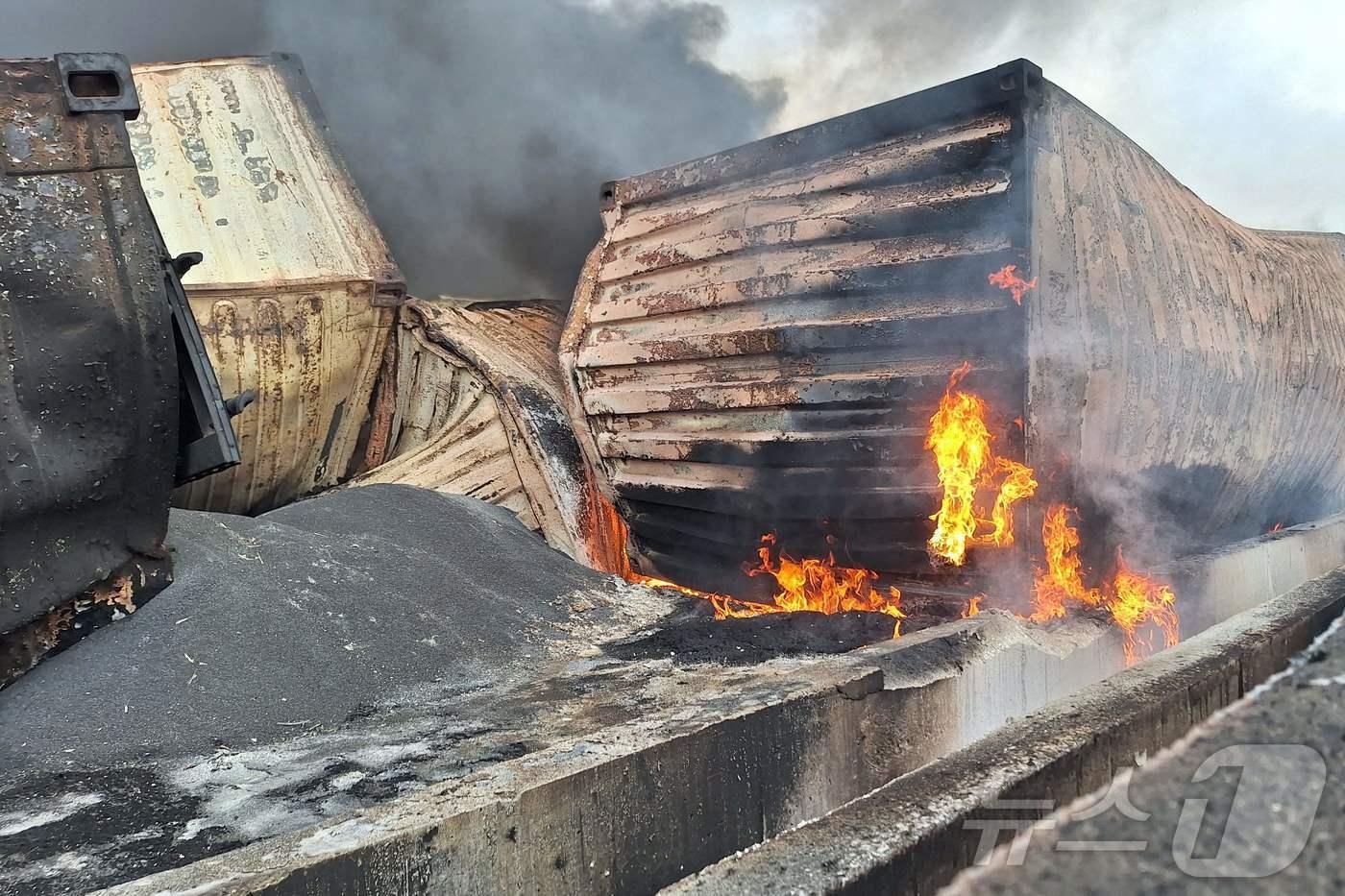 본문 이미지 - 27일(현지시간) 이란 남동부 반다르압바스 지역 샤히드라자이 항구에서 폭발 사고가 발생해 최소 40명이 숨진 현장서 불에 타는 컨테니어가 보인다. 2025.04.28 ⓒ AFP=뉴스1
