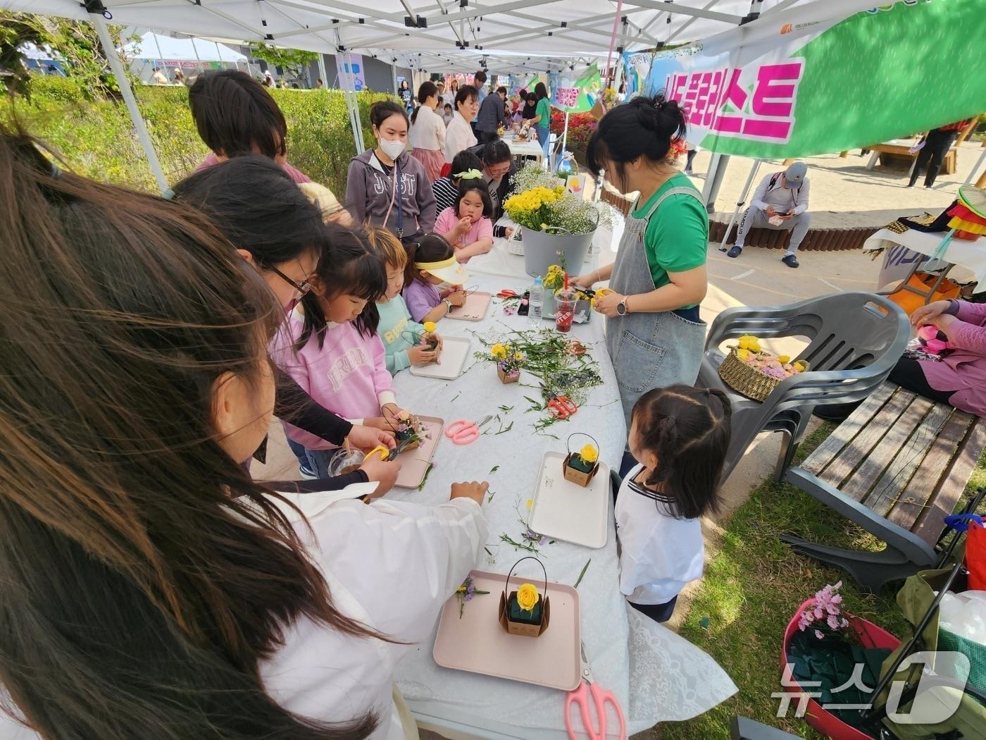 본문 이미지 -  고창군육아종합지원센터가 개관 10주년을 맞아 26일 아이뜨락 생태놀이터에서 ‘제7회 자연아 놀자’ 어린이 생태체험 마당 행사를 개최했다. ‘나도 플로리스트(플라워 클래스)' 행사 장면(센터 제공, 재판매 및 DB금지)
