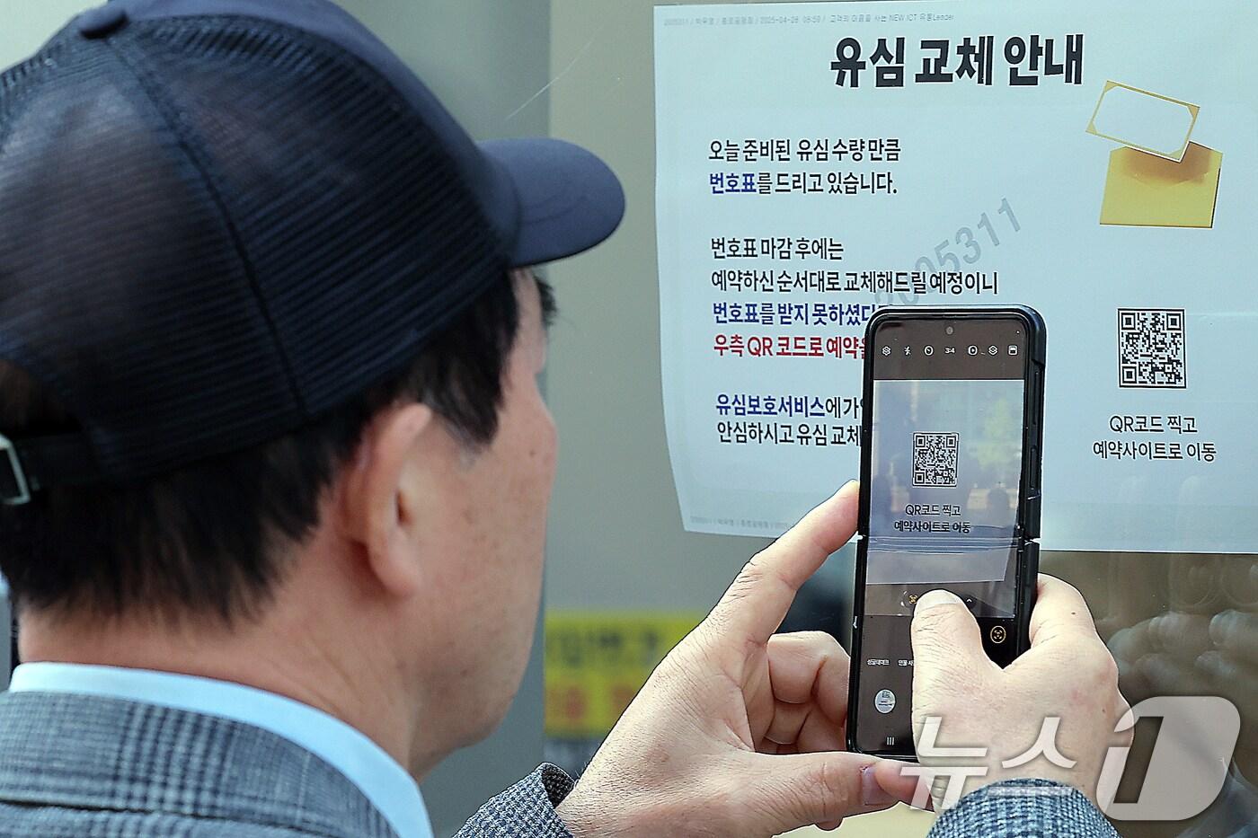 해킹 공격으로 가입자 유심 정보가 탈취된 SK텔레콤이 가입자 유심 무상 교체를 시작한 28일 오전 서울 종로구 T월드 직영매장 앞에서 번호표를 받지 못한 고객이 온라인 예약을 하고 있다. 전국 T월드 매장 2600여 곳과 공항 로밍센터에서 희망하는 고객들에게 순차적으로 유심 무상 교체를 진행하는 SK텔레콤은 현재 유심 100만 개를 확보했으며 5월 말까지 약 500만 개를 추가 확보한다는 방침을 밝혔다. 2025.4.28/뉴스1 ⓒ News1 박정호 기자