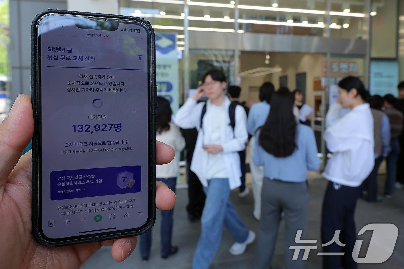 해킹 공격으로 가입자 유심 정보가 탈취된 SK텔레콤이 가입자 유심 무상 교체를 시작한 28일 오전 서울 종로구 T월드 매장 앞에서 직원들의 안내를 받아 온라인 예약을 하고 있다. 2025.4.28/뉴스1 ⓒ News1 박정호 기자