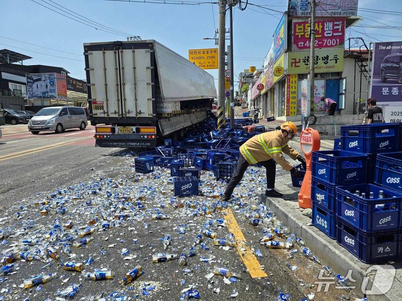 본문 이미지 - 29일 오후 12시 16분쯤 광주 북구 양산동 우체국사거리에서 맥주 300박스가 쏟아져 소방당국이 수습하고 있다.(광주 북부소방 제공. 재판매 및 DB 금지)