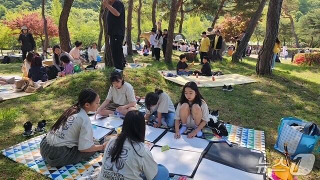 본문 이미지 -  고창문화원이 29일 선운산 도립공원 생태숲 광장에서 ‘고창의 문화, 미래로’를 주제로 제48회 동백연 청소년문화예술경연대회를 개최했다. 대회에 참가한 어린이들이 숲속에서 그림을 그리고 있다.(고창군 제공, 재판매 및 DB금지)