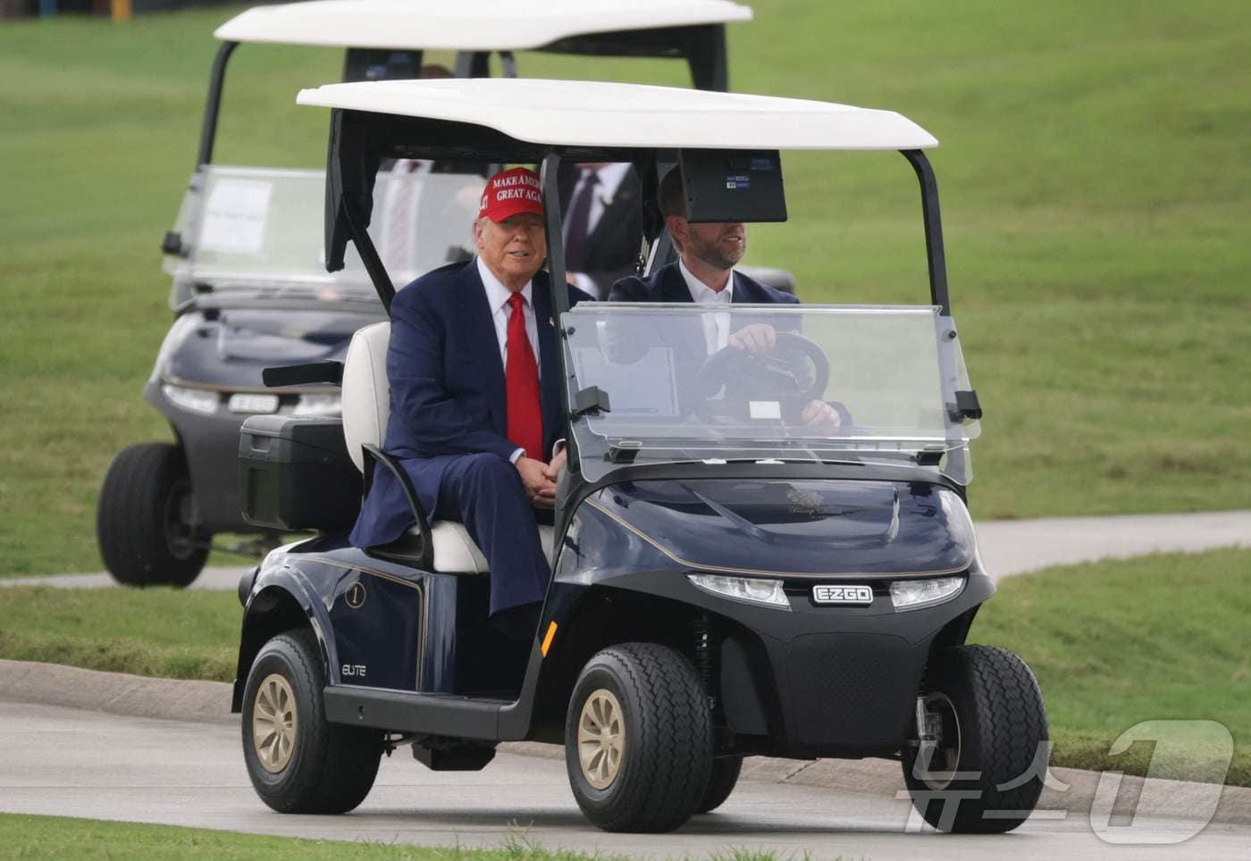 도널드 트럼프 미국 대통령과 아들 에릭이 3일(현지시간) LIV 골프 대회가 열리는 플로리다주 도랄에 있는 트럼프 내셔널 도럴 골프 클럽에서 카트를 타고 이동을 하고 있다. 2025.04.04 ⓒ AFP=뉴스1 