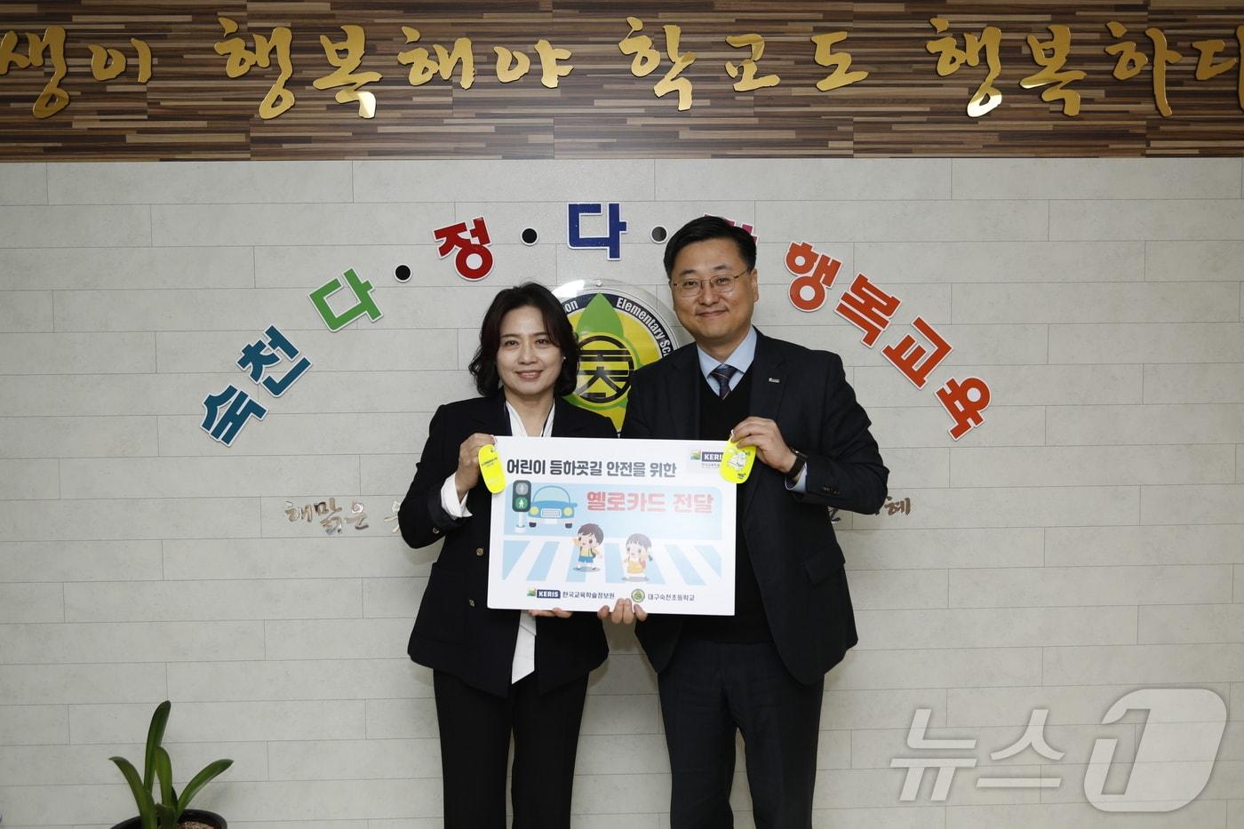 정제영 한국교육학술정보원장(오른쪽)이 교통안전용품 '옐로카드'를 전달하는 모습. (한국교육학술정보원 제공)