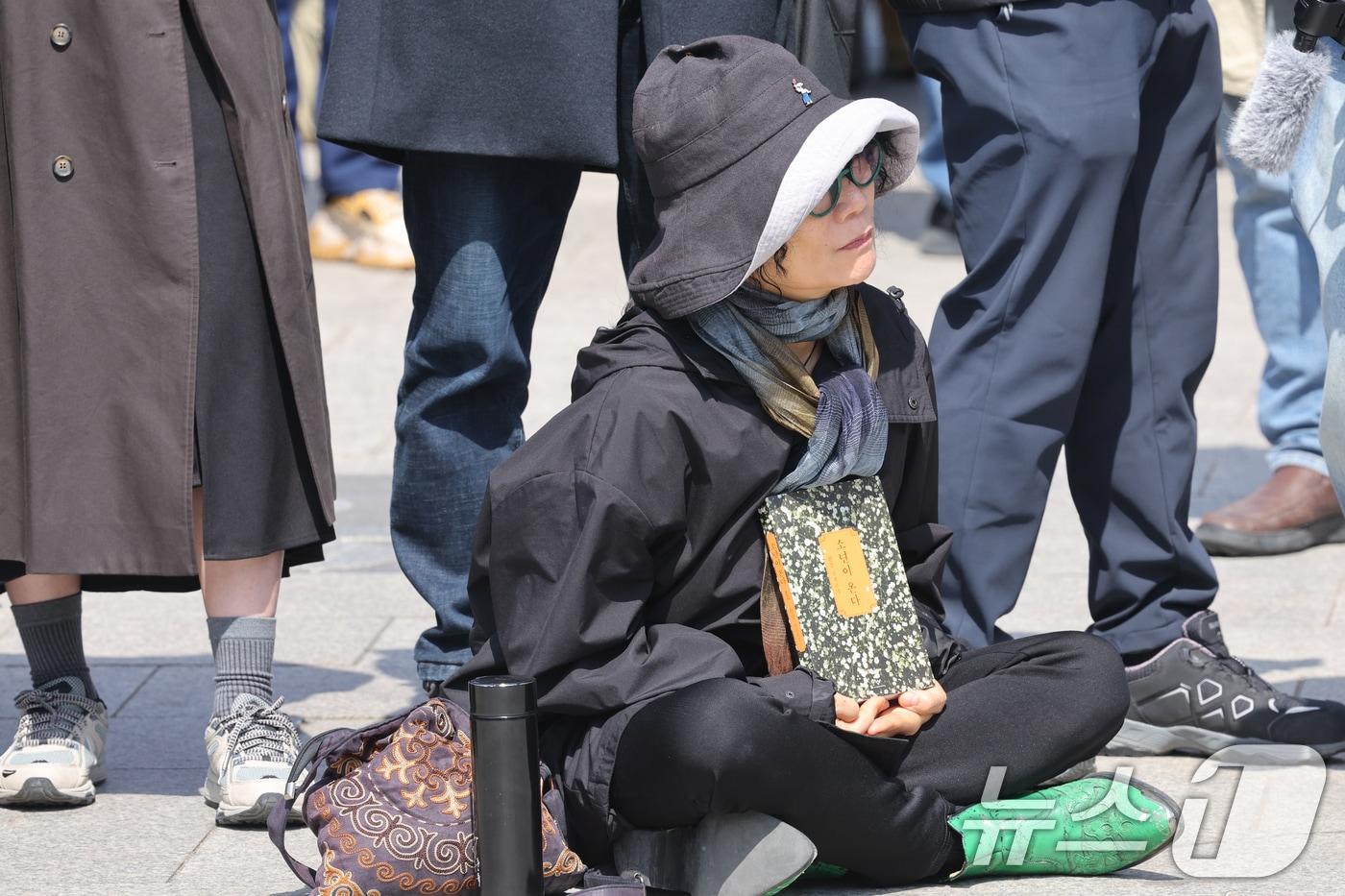 4일 오전 광주 동구 5.18민주광장에는 한 시민이 한강 소년이 온다를 들고 헌법재판소의 윤석열 대통령 탄핵 선고 결과를 기다리고 있다. 2025.4.4/뉴스1 ⓒ News1 김태성 기자