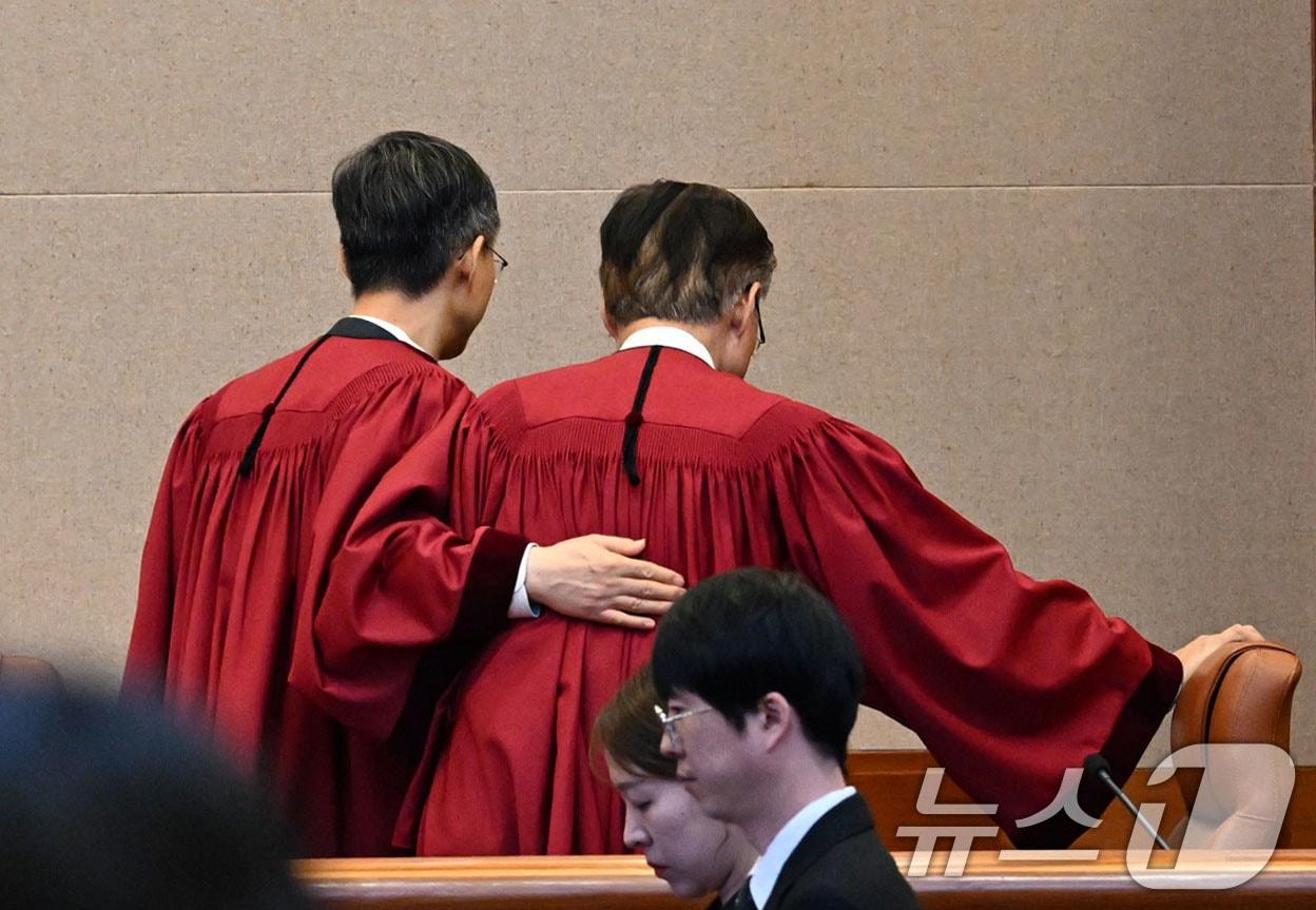 본문 이미지 - 문형배 헌법재판소장 권한대행이 4일 오전 서울 종로구 헌법재판소 대심판정에서 윤석열 대통령 탄핵심판 인용 결정을 선고 한 뒤 김형두 재판관과 함께 법정을 나서고 있다. 이날 헌법재판소는 재판관 전원 일치 의견으로 윤 대통령 파면을 결정했다. 2025.4.4/뉴스1 ⓒ News1 사진공동취재단