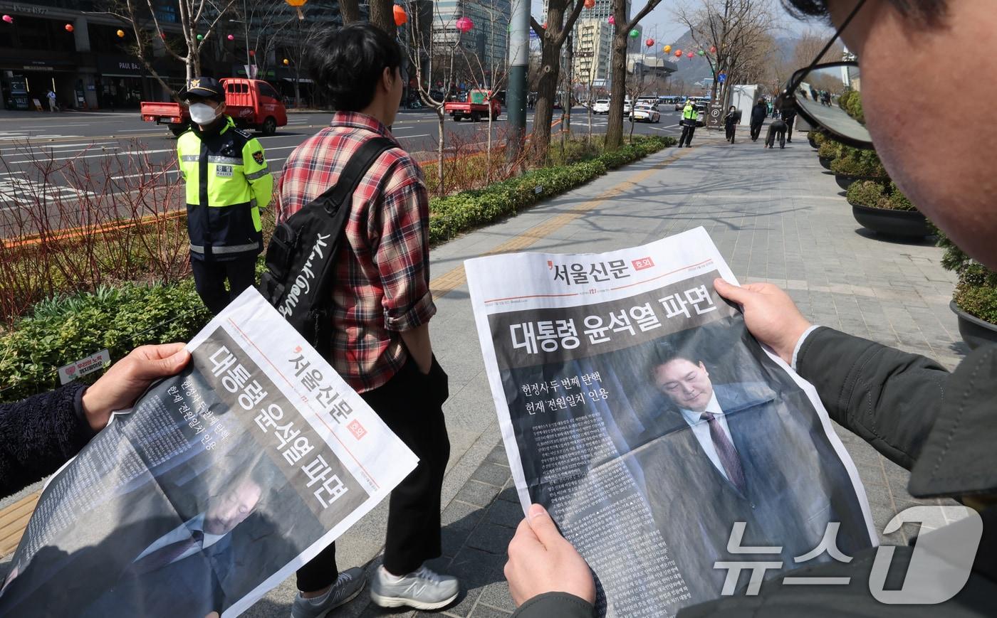 헌법재판소가 윤석열 전 대통령에 대한 탄핵을 인용한 4일 오후 서울 중구 시청역 앞에서 시민이 서울신문이 발행한 호외를 살펴보고 있다. 2025.4.4/뉴스1 ⓒ News1 장수영 기자
