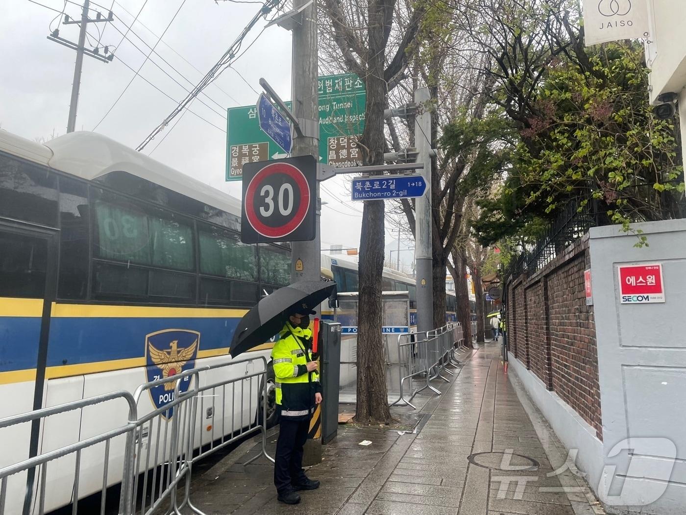 본문 이미지 - 5일 오전 서울 종로구 헌법재판소 일대 한 경찰이 우산을 쓰고 서 있다. 20250405/뉴스1 ⓒ News1 임여익 기자