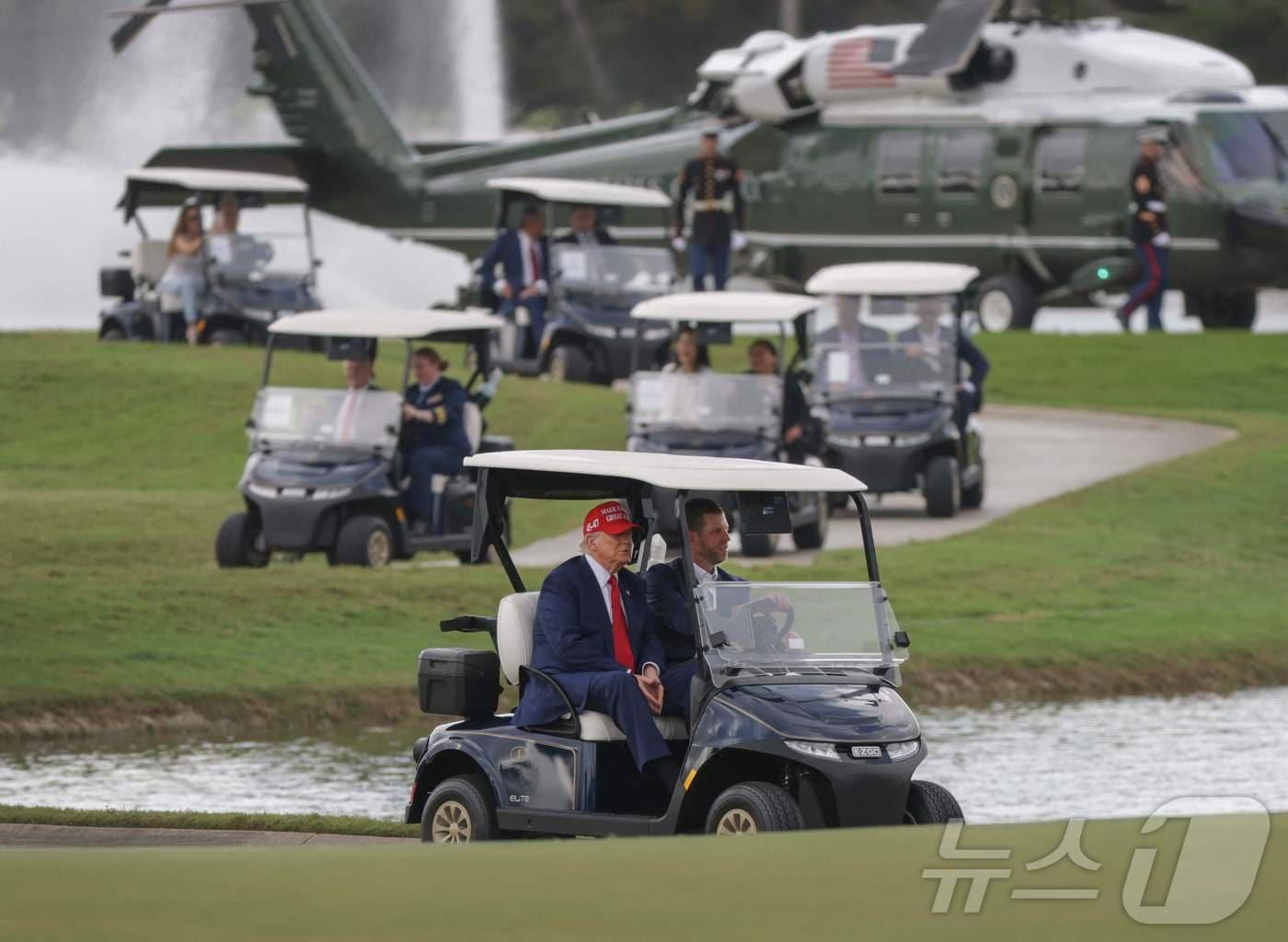 본문 이미지 - 도널드 트럼프 미국 대통령과 아들 에릭이 3일(현지시간) LIV 골프 대회가 열리는 플로리다주 도랄에 있는 트럼프 내셔널 도럴 골프 클럽에 전용 헬기를 타고 도착해 카트를 타고 하고 있다. 2025.04.04 ⓒ AFP=뉴스1 ⓒ News1 우동명 기자