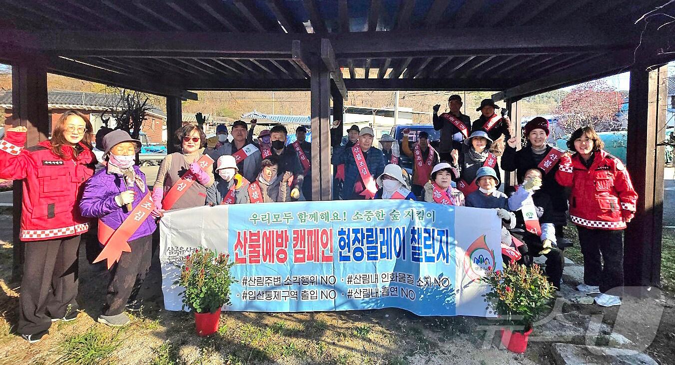 본문 이미지 - 7일 부계면 창평2리 주민들이 '군위형 마을만들기 사업'과 연계해 꽃 화단 조성과 나무식재에 앞서 산불 예방 캠페인에 동참하고 있다. (군위군 제공)