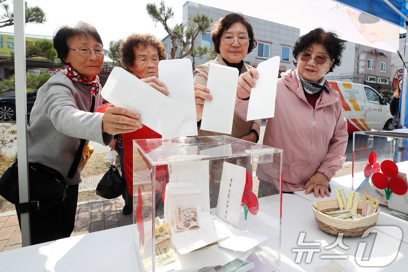 8일 오전 대구 군위군 군위전통시장 앞에서 열린 경북 산불피해 지역 돕기 거리모금에 참여한 주민들이 성금을 전달하고 있다. ⓒ News1 공정식 기자