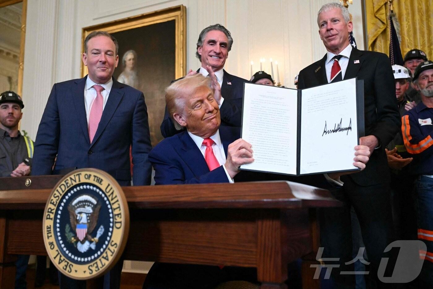 본문 이미지 - 도널드 트럼프 미국 대통령이 8일(현지시간) 워싱턴 백악관에서 열린 석탄 산업을 활성화하는 행정명령에 서명을 한 뒤 들어 보이고 있다. 2025.04.09 ⓒ AFP=뉴스1 ⓒ News1 우동명 기자