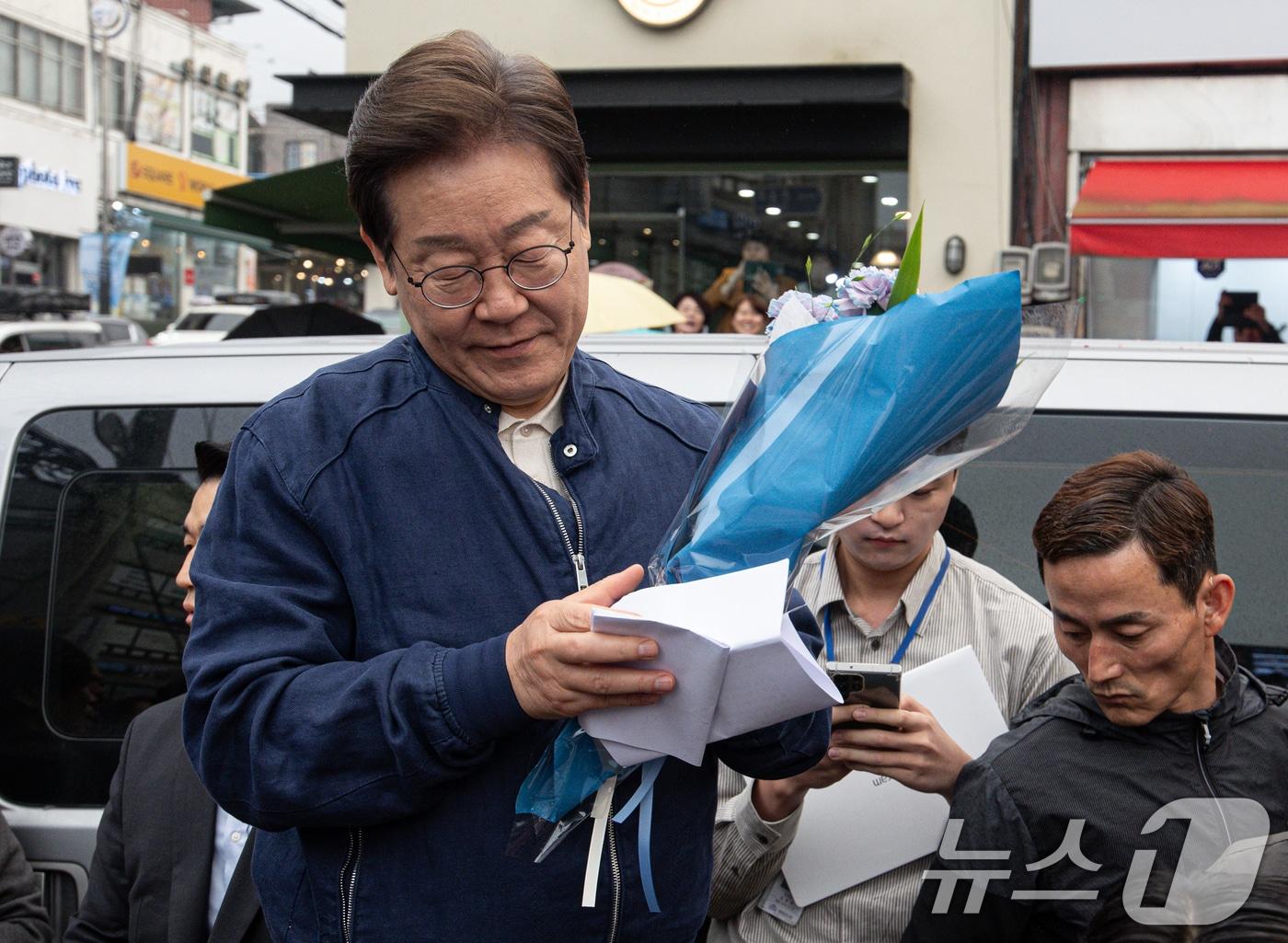 본문 이미지 - 이재명 더불어민주당 대통령 후보가 1일 오후 경기도 연천군 전곡시외터미널 인근에서 선물받은 꽃다발과 편지를 살펴보고 있다. 2025.5.1/뉴스1 ⓒ News1 이재명 기자
