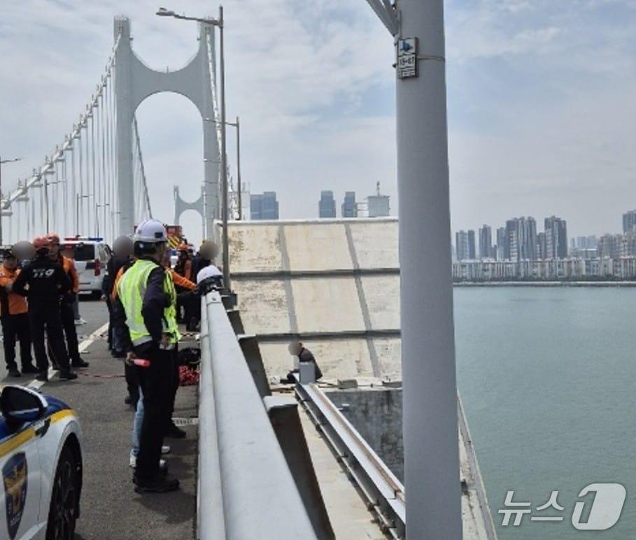 본문 이미지 - 50대 남성이 부산 광안대교 상판 난간에서 농성을 하고 있다.&#40;해운대경찰서 제공. 재판매 및 DB 금지&#41;