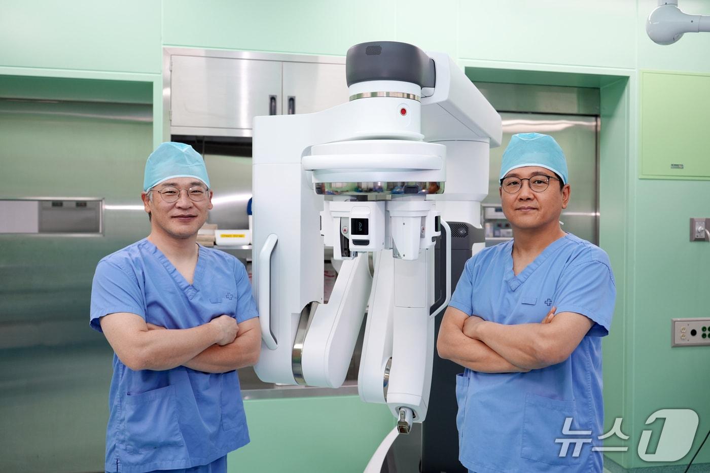 인제대 해운대백병원 갑상선·내분비외과의 배동식 교수&#40;왼쪽&#41;와 구도훈 교수가 다빈치 SP 로봇수술기 앞에서 기념촬영을 하고 있다.&#40;해운대백병원 제공. 재판매 및 DB 금지&#41;