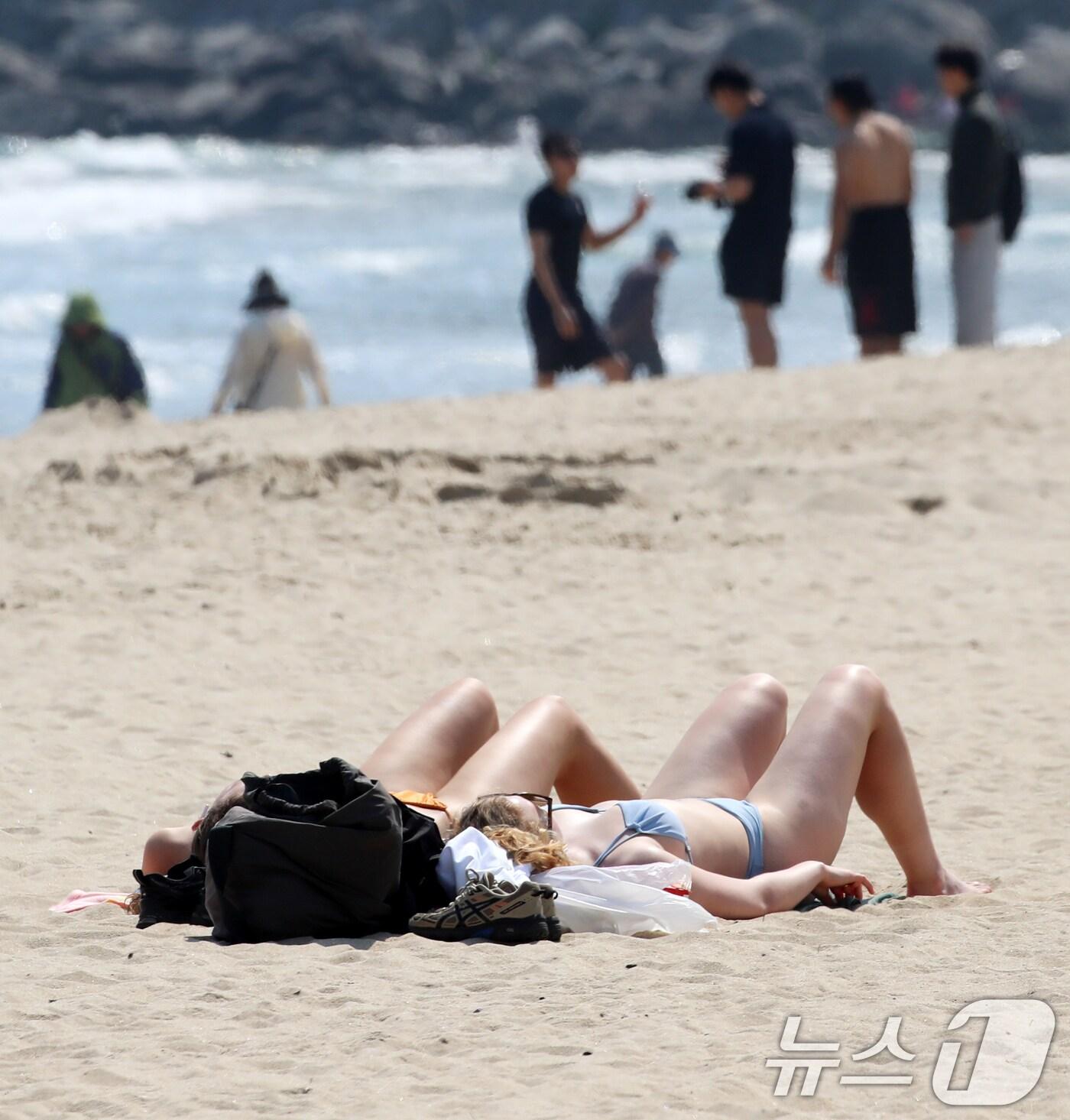 본문 이미지 - 초여름 날씨를 보인 12일 오후 부산 해운대해수욕장을 찾은 관 외국인들이 태닝을 즐기고 있다. 2025.5.12/뉴스1 ⓒ News1 윤일지 기자