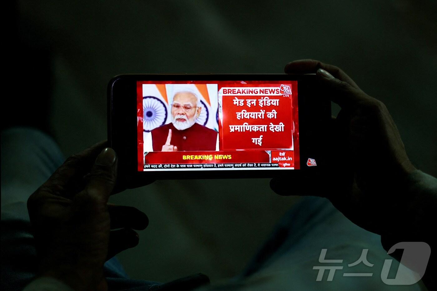 인도 델리에서 한 남성이 휴대폰으로 나렌드라 모디 인도 총리의 대국민 연설을 시청하고 있다. 2025.05.12 ⓒ 로이터=뉴스1 ⓒ News1 정지윤 기자