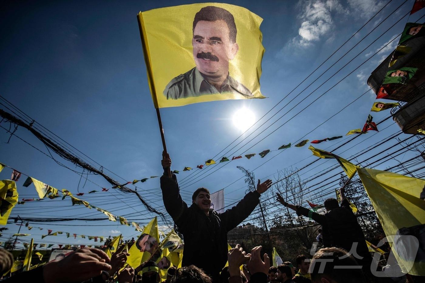 지난 2월15일&#40;현지시간&#41; 시리아 북동부 쿠르드족이 다수 거주하는 도시인 카미슐리에서 열린 1999년부터 튀르키예에 수감돼 있는 쿠르드노동자당&#40;PKK&#41; 지도자 압둘라 외잘란의 석방을 요구하는 시위에서 한 시위자가 그의 초상화가 그려진 깃발을 흔들고 있다. 25.02.15 ⓒ AFP=뉴스1 ⓒ News1 김예슬 기자