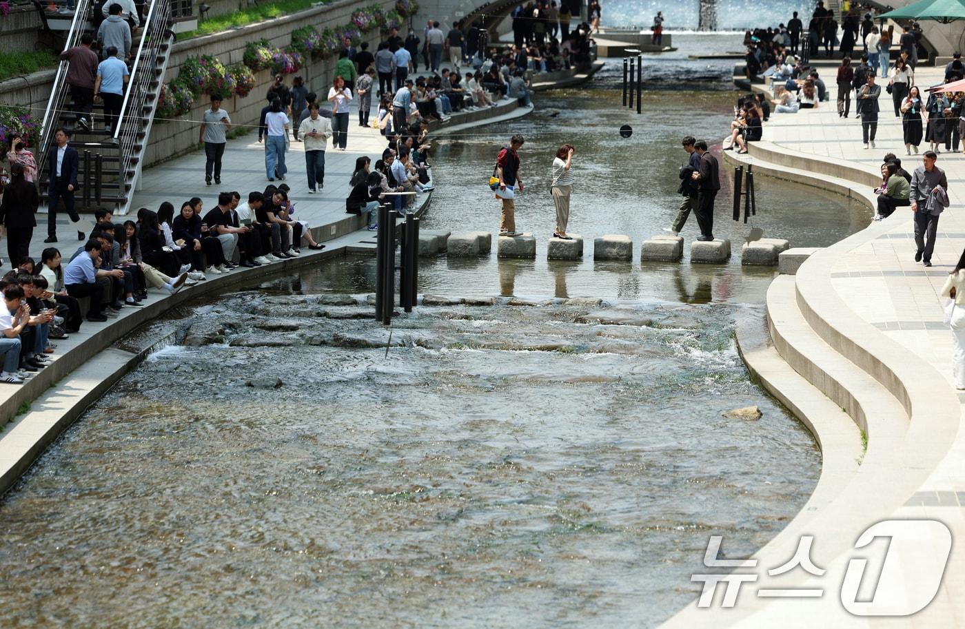 서울 청계천에서 직장인들이 점심시간을 이용해 그늘에서 휴식을 취하고 있다. ⓒ News1 김명섭 기자