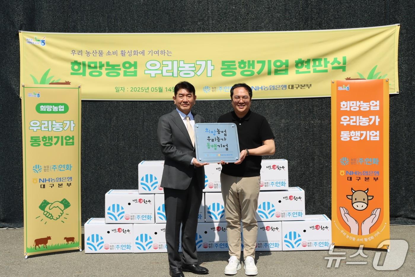 본문 이미지 - 손영민 NH농협은행 대구본부장(왼쪽)이 희망농업 우리농가 동행기업으로 선정된 ㈜연화의 강민균 대표에게 현판을 전달하고 있다.(NH농협 대구본부 제공. 재판매 및 DB 금지)
