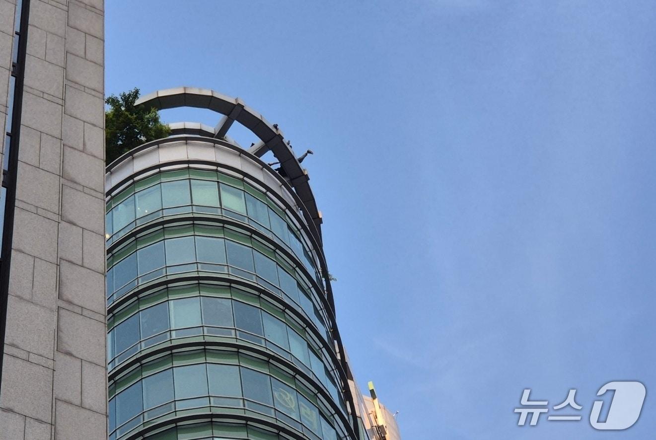 본문 이미지 - 지난 13일 오후 3시쯤 서울 지하철 강남역 11번 출구 인근 한 고층 빌딩에 한 남성이 서있다는 신고가 접수됐다. 사진은 3시간 28분 만인 오후 6시 28분 남성이 소방관에 의해 구조되는 모습. ⓒ 뉴스1 남해인 기자