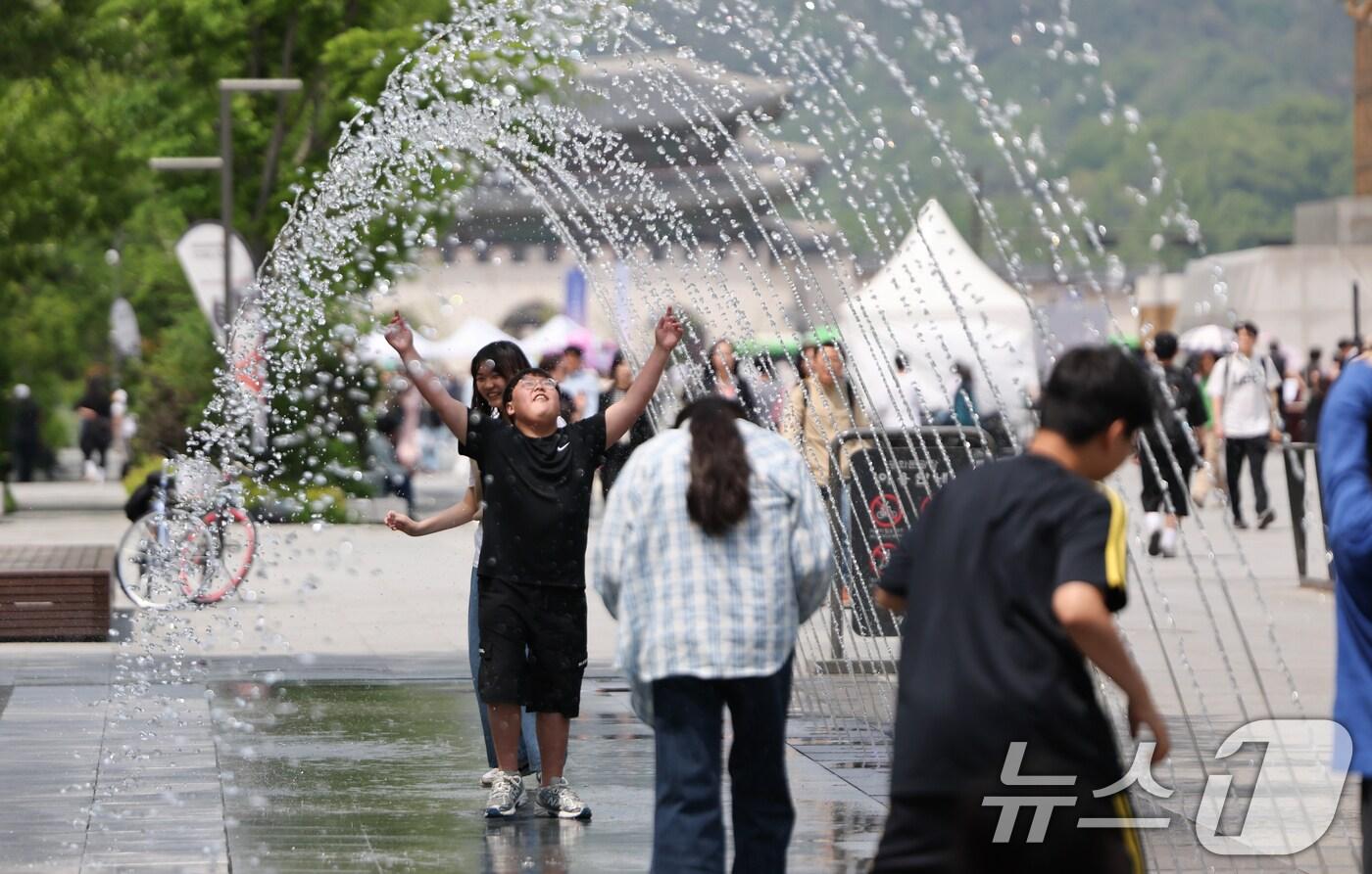본문 이미지 - 서울 낮 최고 기온 26도 등 초여름 날씨을 보인 14일 서울 광화문광장 분수터널에서 시민들이 더위를 식히고 있다. 2025.5.14/뉴스1 ⓒ News1 허경 기자