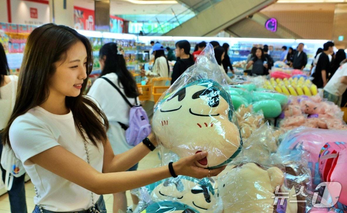 본문 이미지 - 서울 잠실 롯데월드몰 1층 아트리움 광장 '짱구는 여행중' 팝업 행사장에서 고객이 상품을 구경하고 있다.(롯데백화점 제공. 재판매 및 DB 금지)