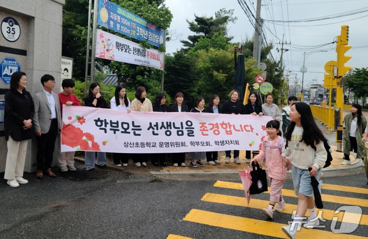 본문 이미지 - 진천상산초등학교 학교운영위원회와 학부모회는 이날 등굣길 학교 교문 앞에서 선생님 존경 캠페인을 진행했다.(진천교육지원청 제공)/뉴스1