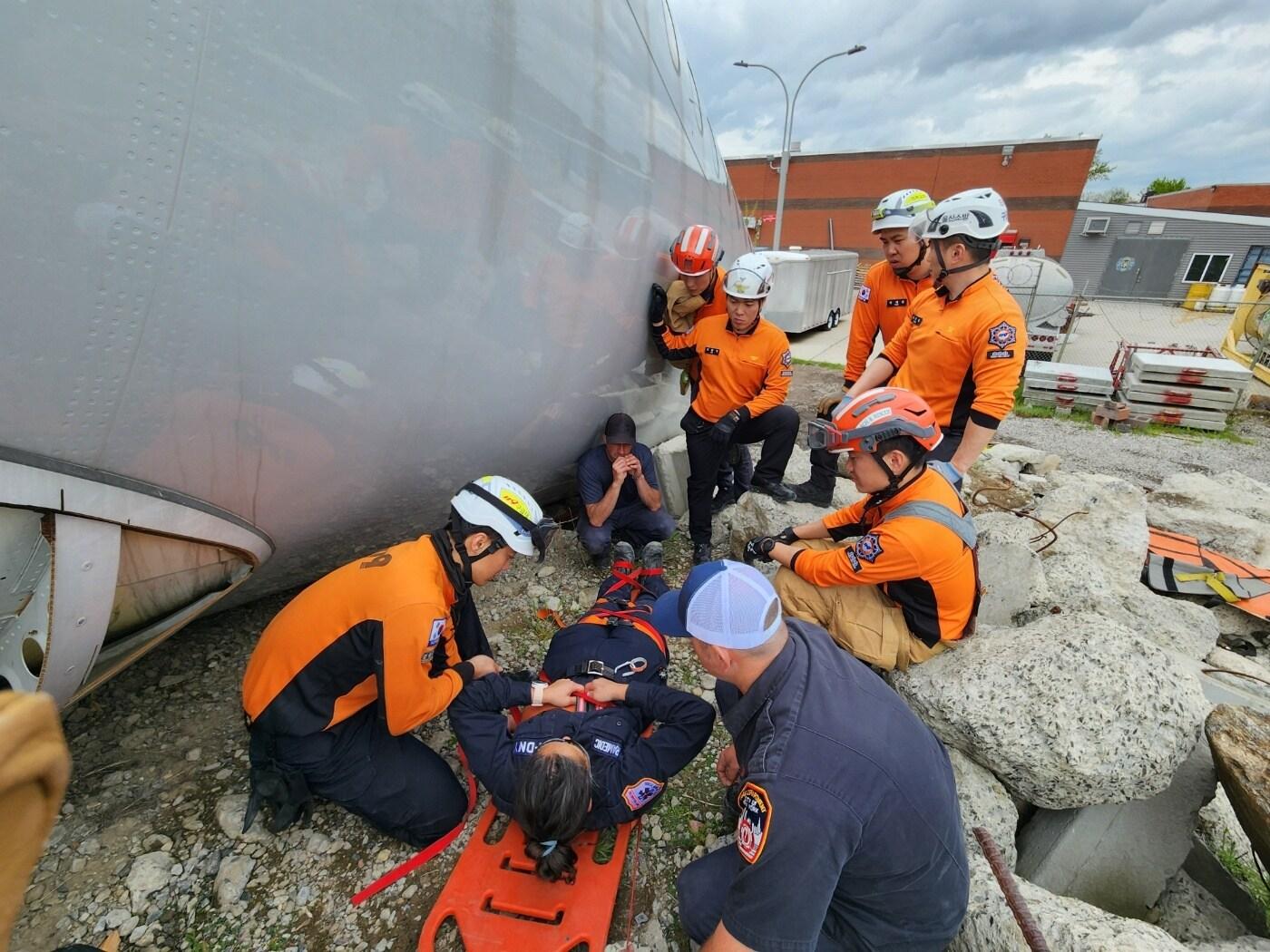 본문 이미지 - 국외연수에 참가한 한국과 미국 구급대원들이 실제 상황을 가정한 훈련장에서 응급처치 등 훈련에 임하고 있다(소방청 제공)