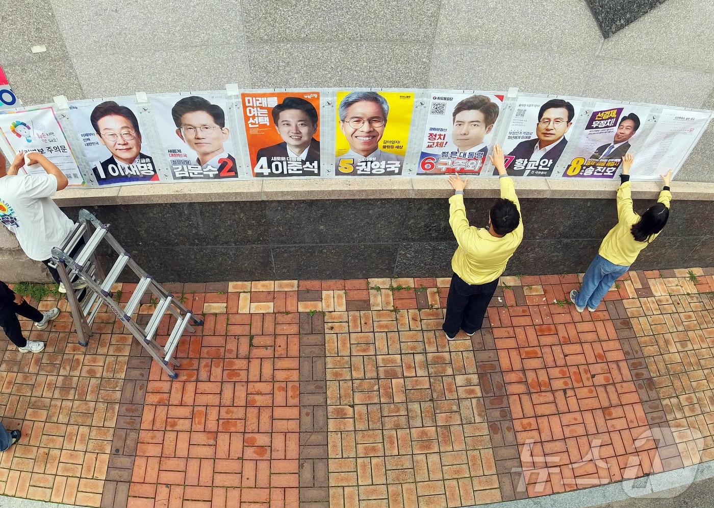 제21대 대통령 선거 벽보 부착 시작 첫날인 15일 광주 북구 운암사거리 인근에서 운암1동 행정복지센터 직원들과 관계자들이 후보자들의 벽보를 붙이고 있다.&#40;광주 북구 제공. 재판매 및 DB 금지&#41; 2025.5.15/뉴스1 