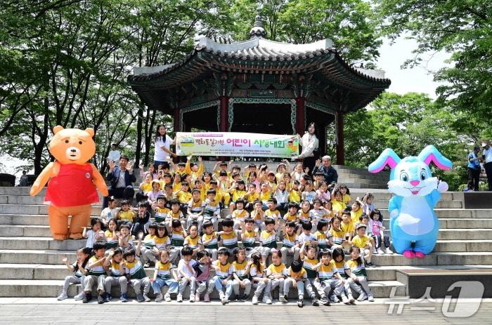 본문 이미지 - 14 일 서울 남산 일대에서 열린 ‘2025 평화통일기원 어린이 사생대회’에 참석한 어린이들과 한국삭도공업 및 동행연우회 관계자들이 기념촬영을 하고 있다. (좌측 상단 사단법인 동행연우회 김영태 대표이사, 우측 상단 한국삭도공업 허필입 본부장) 사진=한국삭도공업 제공