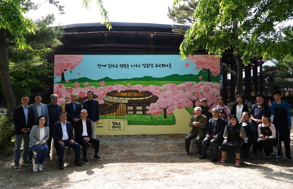 본문 이미지 - 15일 인천 강화도에 위치한 발달장애인 직업재활시설 강화도 우리마을 외벽 벽화 앞에서 풀무원 이우봉 총괄CEO&#40;사진 첫 번째 줄 왼쪽 두 번째&#41;와 사업단위 대표들이 강화도 우리마을 설립자 대한성공회 김성수 주교&#40;사진 첫 번째 줄 오른쪽 세 번째&#41;, 우리마을 최수재 원장 신부&#40;사진 첫 번째 줄 오른쪽 두 번째&#41;, 벽화 채색 작업에 참여한 강화도 우리마을 발달장애인 및 근로자들과 단체 사진을 촬영하고 있다. 이날 풀무원은 벽화 그리기 봉사와 셰프 만찬, 기부금 전달 등 다양한 사회공헌활동을 진행했다. &#40;풀무원 제공&#41;