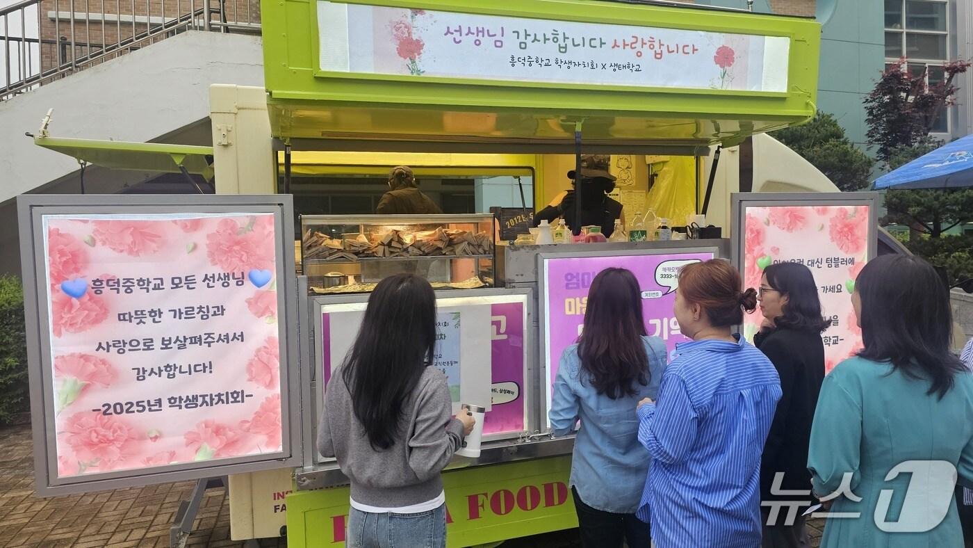 흥덕중 학생자치회가 준비한 커피차에서 커피를 받으려 줄을 서 있는 선생님들 모습.(흥덕중 제공)