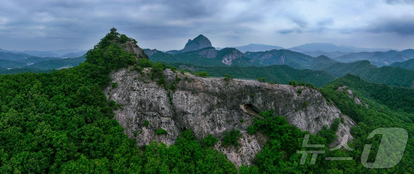 바위 절벽 위 정자와 그 뒤로 겹겹이 이어진 산능선 멀리 보이는 마이산의 두 봉우리가 차분하게 솟아 신바한 분위기를 담아낸다.(진안군제공. 재판매 및 DB금지)2025.5.16/뉴스1