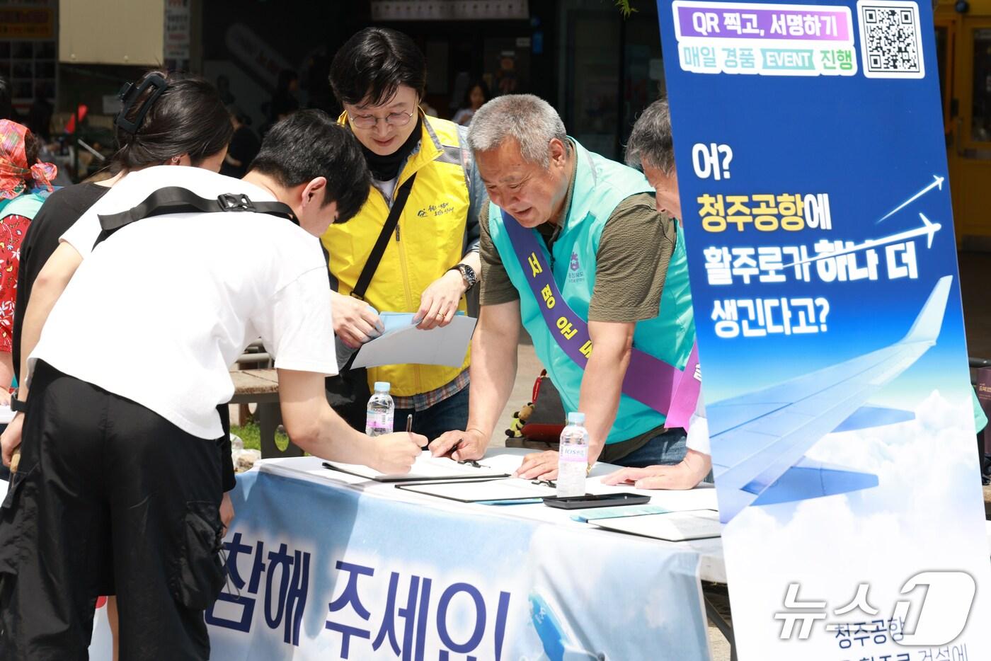 본문 이미지 - 17일 충북도 도민홍보대사들이 청주시 성안길에서 청주공항 민간 활주로 건설을 촉구하는 서명운동을 펼치고 있다.(충북도 제공. 재판매 및 DB금지) /뉴스1 