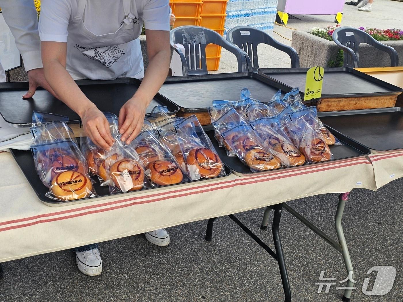 본문 이미지 - 광주 대표 빵집 중 하나인 궁전제과가 17일 5·18 전야제 부스에서 대통령 선거 투표를 독려하는 '선거빵'을 판매하고 있다. 2025.5.17/뉴스1