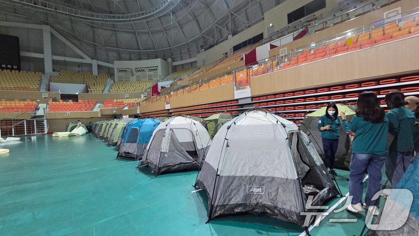 17일 오전 발생한 금호타이어 광주공장 화재 여파로 검은 연기가 퍼지면서 대피를 희망하는 주민들을 위해 광산구 공직자들이 광주여대 체육관에 400세대를 수용할 수 있는 텐트를 설치하고 있다. &#40;광산구 제공. 재판매 및 DB 금지&#41; 